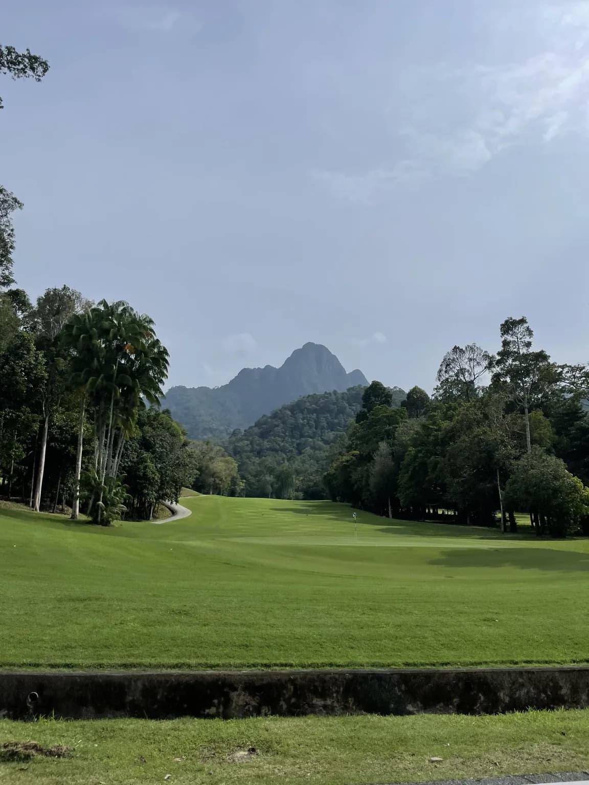 Zelené golfové hřiště na Langkawi obklopené pralesem a horskými vrcholy