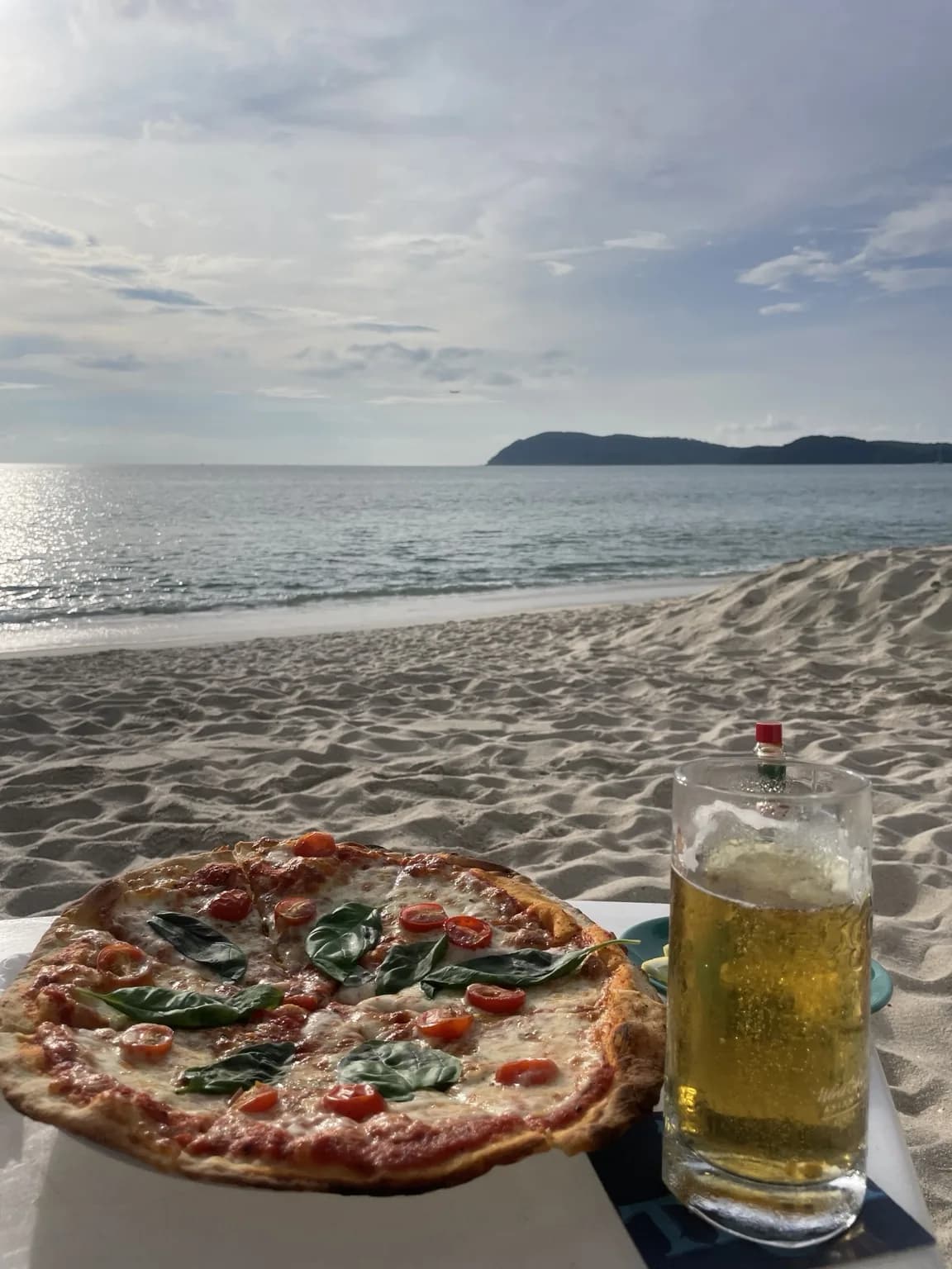 Pizza a sklenice piva u pláže s výhledem na Andamanské moře