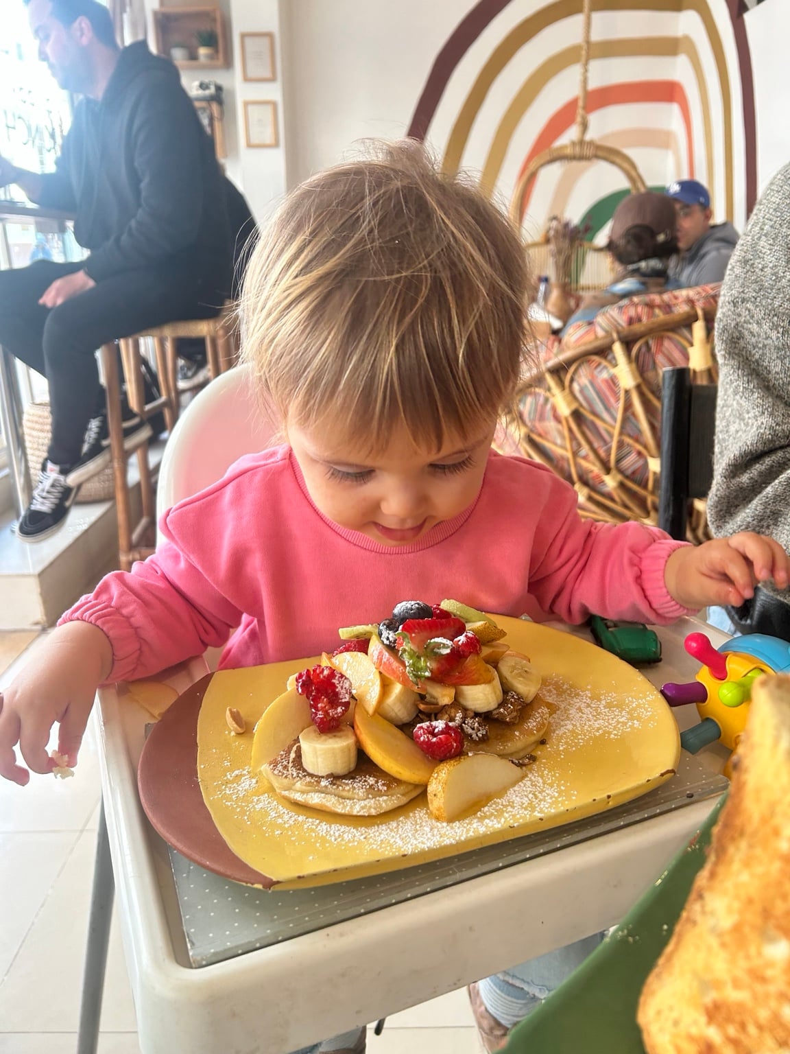 Dítě u talíře s palačinkami a ovocem v Boho Café
