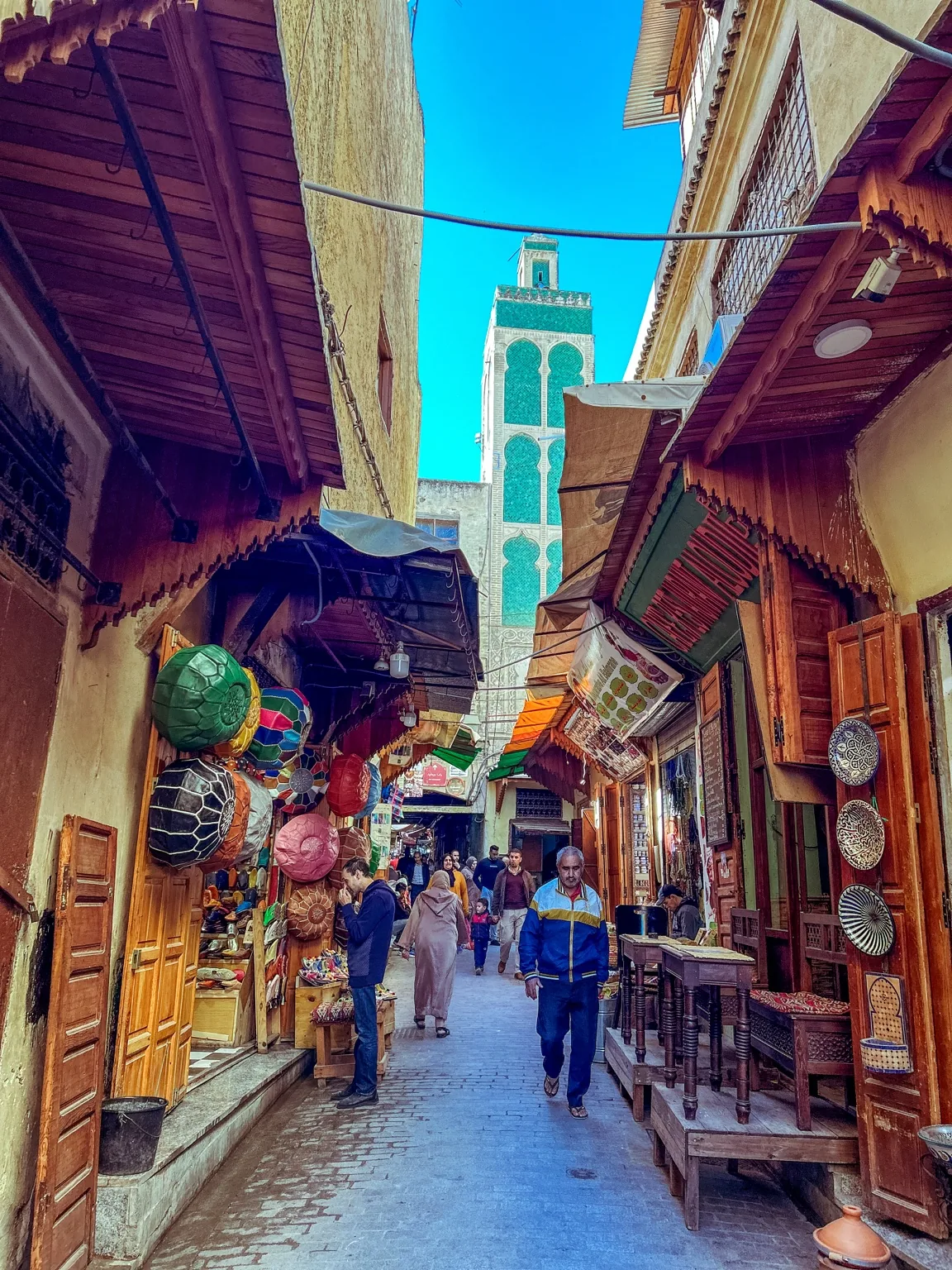 Ulice v medině ve Fezu s minaretem mezi tradiční zástavbou