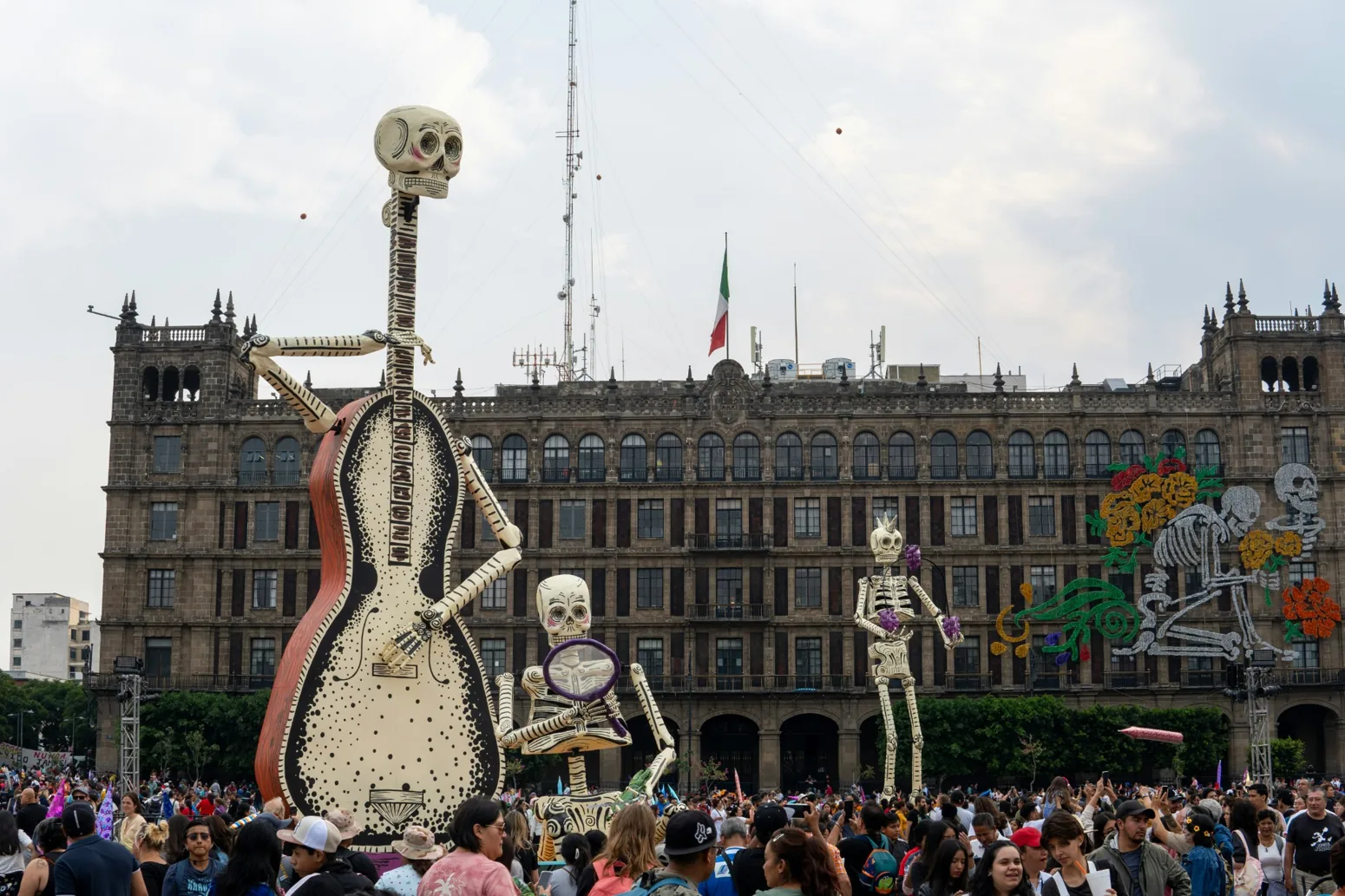 Obří kostlivci s kytarou při oslavách Día de Muertos na náměstí Zócalo v Mexico City