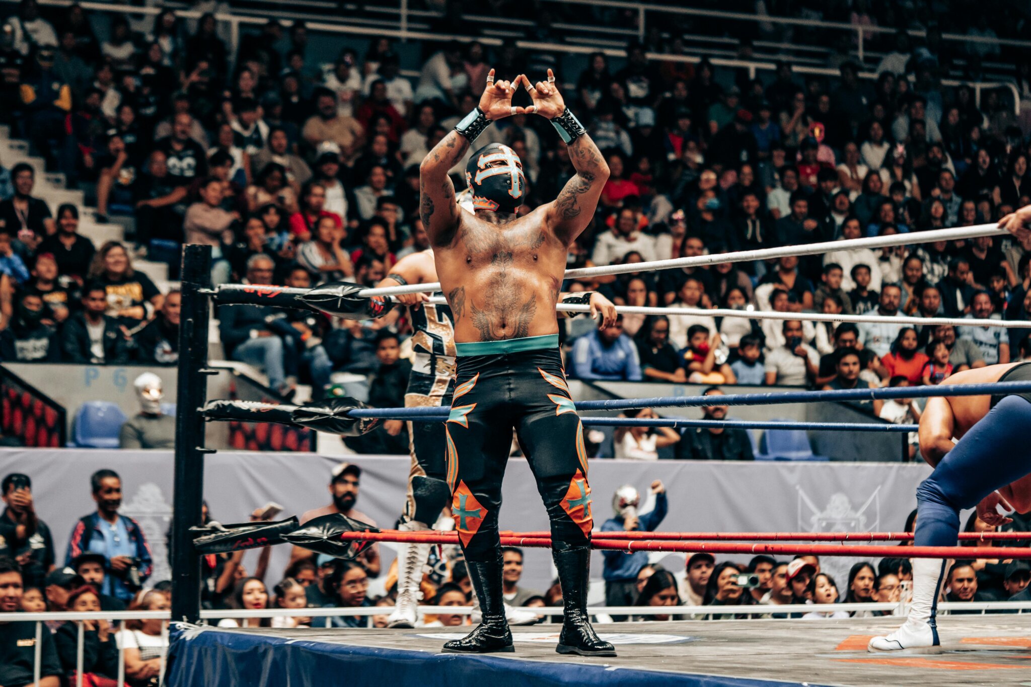 Turistické atrakce v Mexico City - Zápasník v ringu během show Lucha Libre v aréně v Mexico City, se světly a diváky v pozadí.