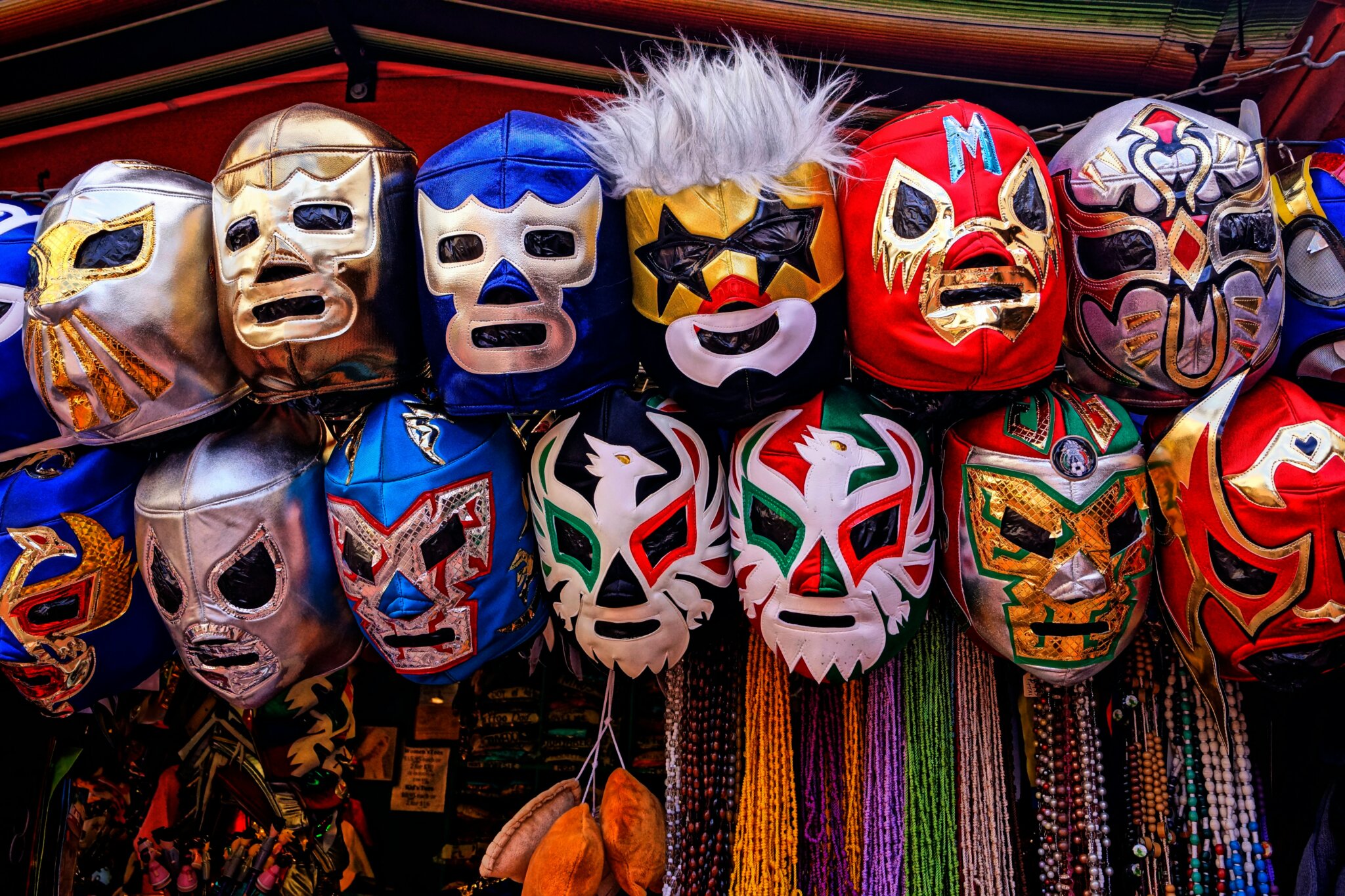 Co dělat v Mexico City? Barevné masky Lucha Libre vystavené na trhu v Mexico City, symbol mexické popkultury a zápasnické tradice.
