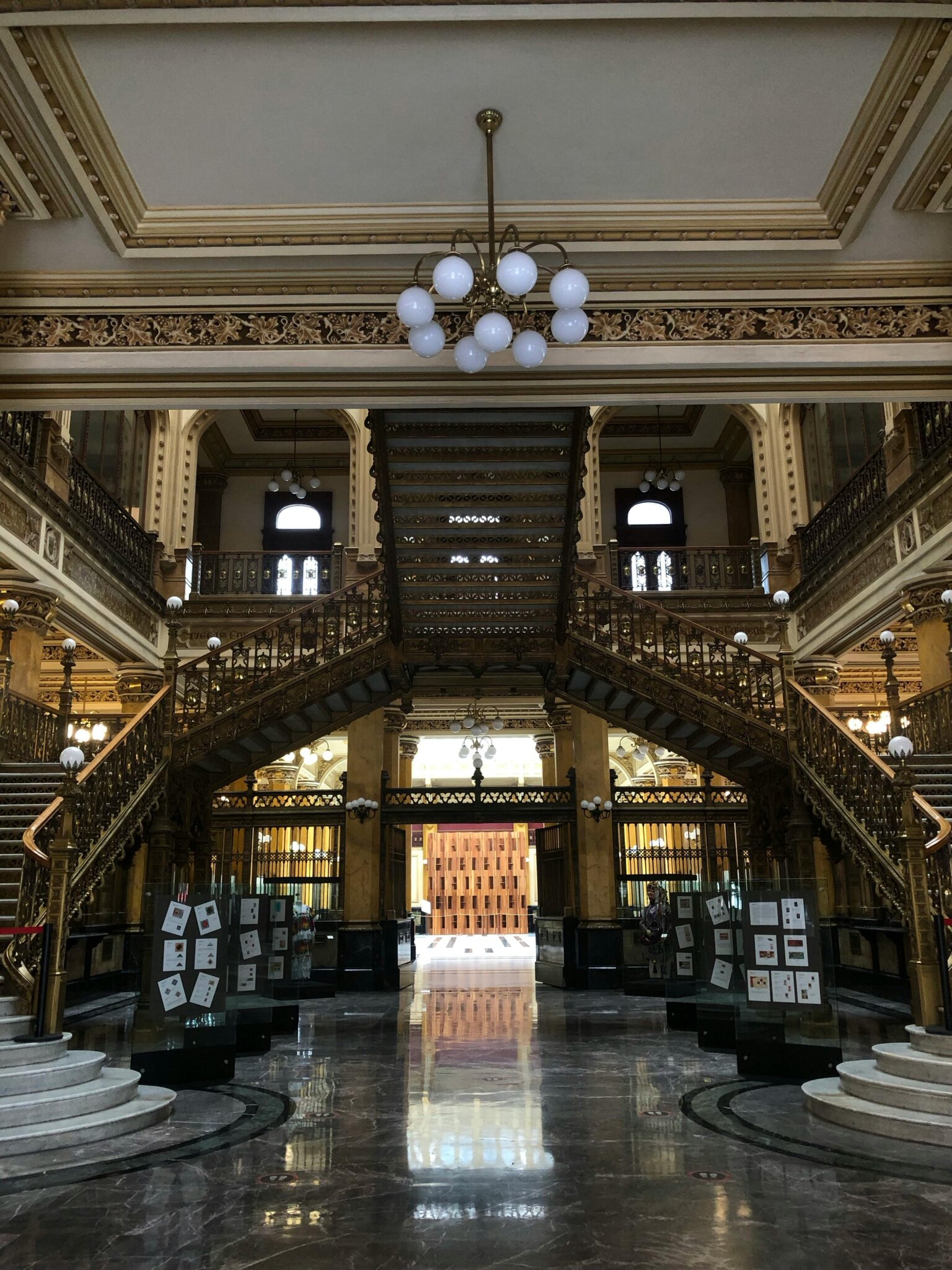 Co dělat v Mexico City? Interiér Palacio Postal v Mexico City s monumentálním schodištěm a zlatými detaily.