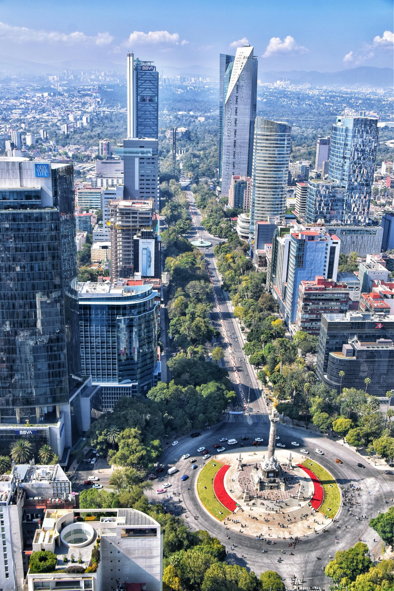 Letecký pohled na Paseo de la Reforma a Anděla nezávislosti v Mexico City – moderní bulvár lemovaný mrakodrapy a stromy.