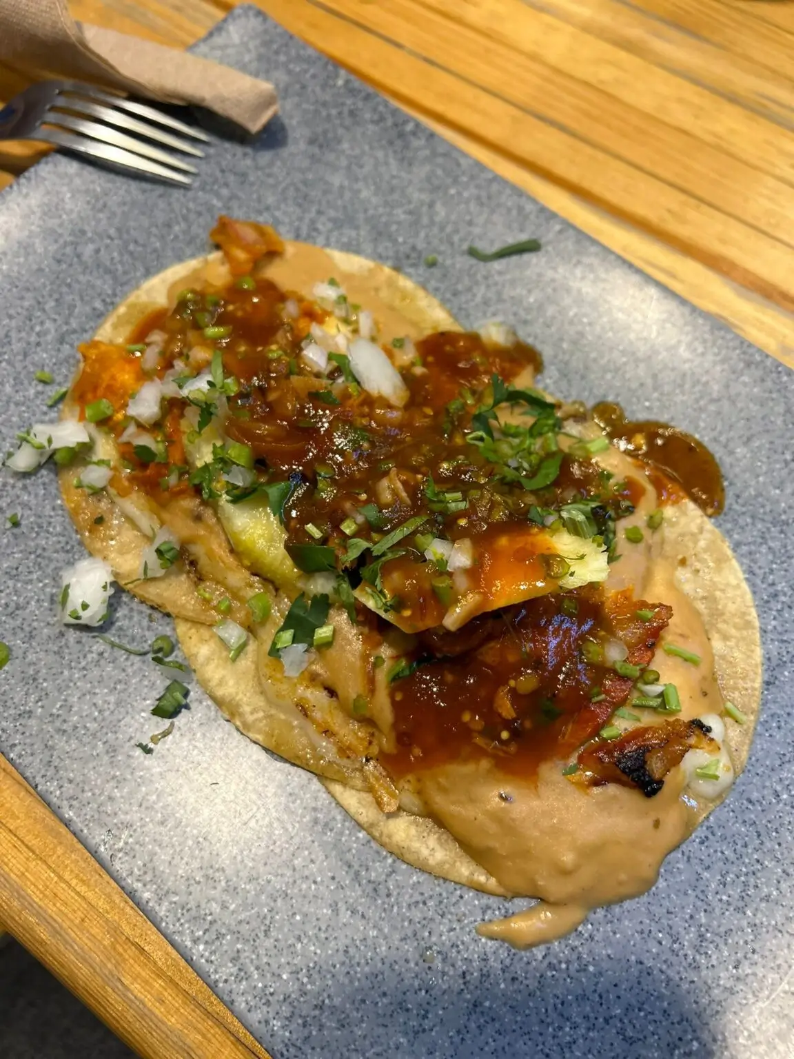 Tacos al pastor z restaurace El Tizoncito s ananasem a cibulí.