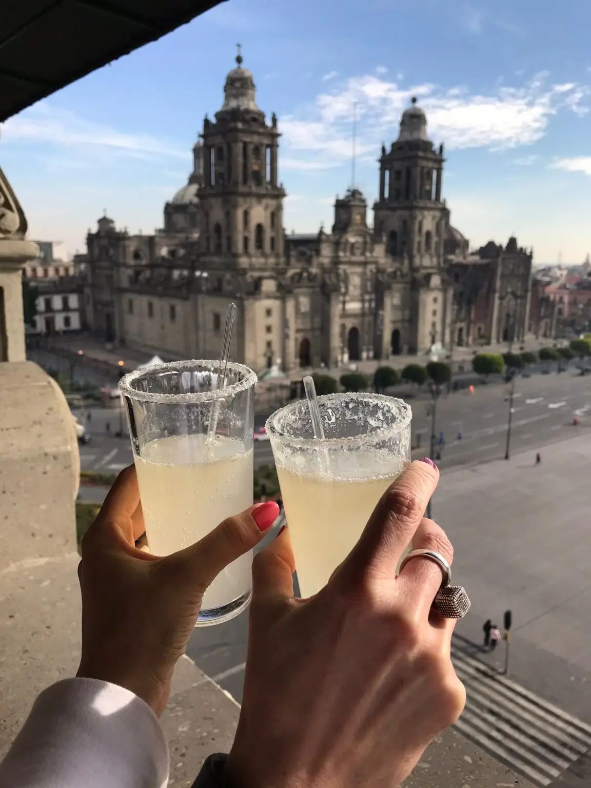 Výhled na Zócalo a Metropolitní katedrálu v Mexico City s margaritou v ruce.