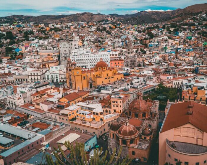 Průvodce po Mexiku: Panoramatický pohled na mexické město Guanajuato s univerzitou a barevnými koloniálními domy.