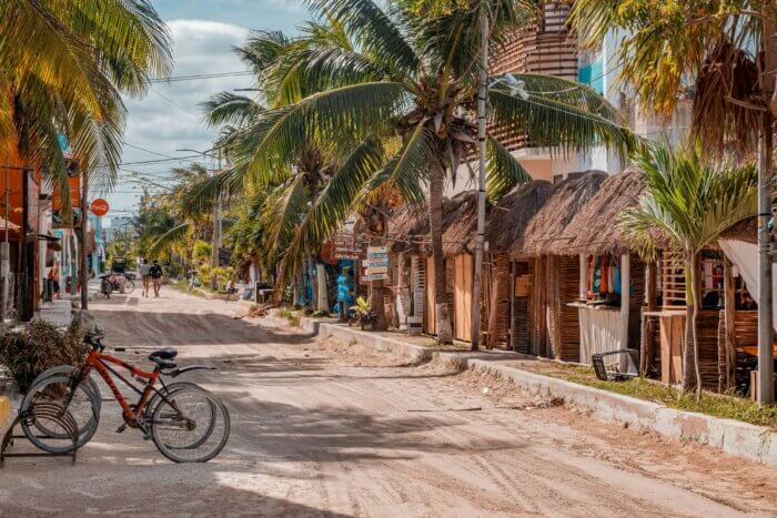 Písečná ulice s barevnými domky na tropickém ostrově Holbox v Mexiku.