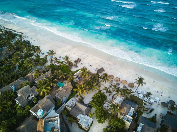 Letecký pohled na karibskou pláž a molo v letovisku Puerto Morelos mezi Cancúnem a Playa del Carmen.