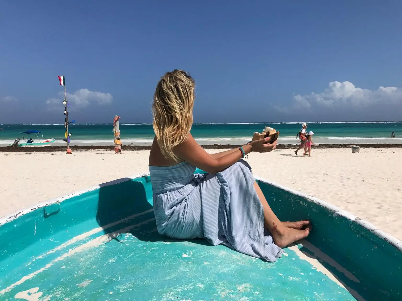 žena v tyrkysové lodi na pláži Playa Paraíso v Tulum