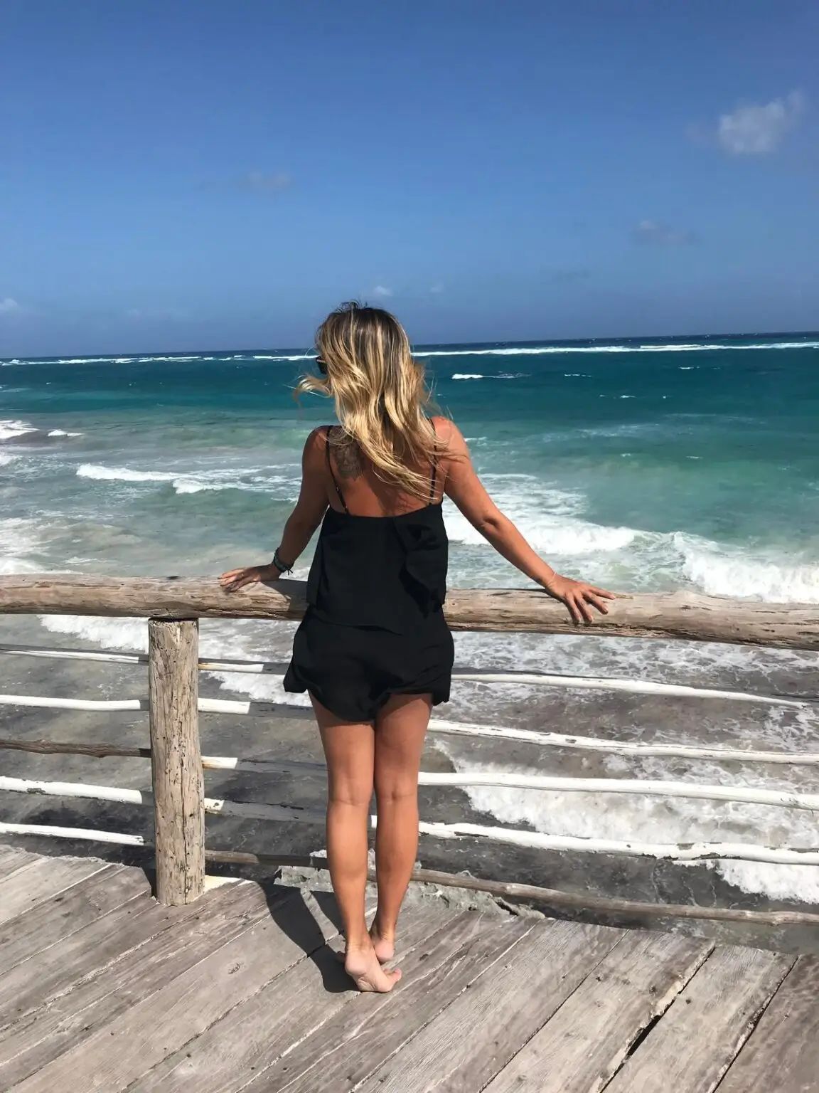 Postava ženy pozorující tyrkysové karibské moře v Tulum