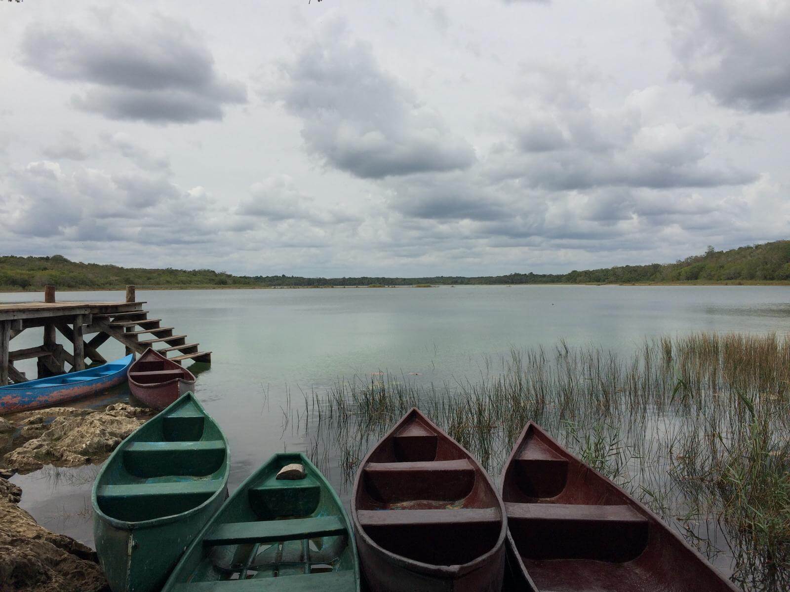 Jezero a barevné dřevěné loďky u rezervace opice pavoučí na poloostrově Yucatán