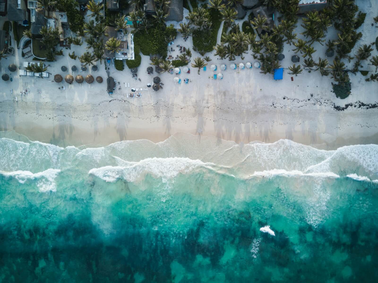 Letecký pohled na pláž v Tulumu s bílým pískem, palmami a tyrkysovým Karibským mořem na Riviera Maya ve státě Quintana Roo na poloostrově Yucatan v Mexiku